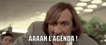 a man in a suit says aaaah l agenda