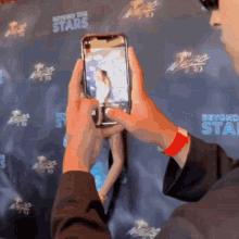 a man is taking a picture of a woman in front of a wall that says beyond the stars