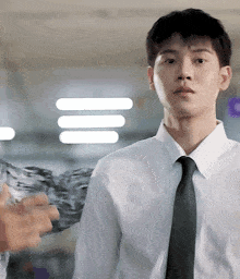 a man in a white shirt and black tie is looking at the camera