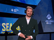 a man in a green suit is standing in front of a sign that says arvel rivals ignite