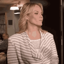 a woman wearing a grey and white striped sweater