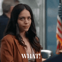 a woman in a brown jacket has the word what on her face