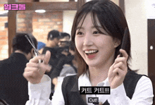 a girl is holding a pair of scissors and smiling with a caption that says " cut "
