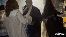 a group of people are dancing in a dark room with the words imgplay on the bottom right