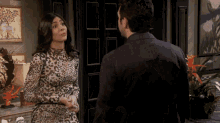 a woman in a leopard print dress stands next to a man in a black suit
