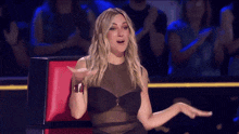 a woman in a black dress is sitting in a red chair