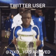 a man holding a trophy with the twitter user @zixd_has arrived