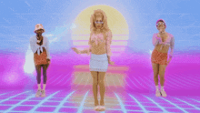 three women are dancing in front of a sunset