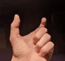 a close up of a person 's hand making a thumbs up gesture .
