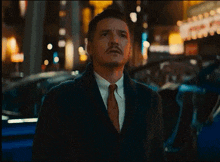 a man in a suit stands in front of a theater