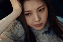 a close up of a woman 's face with her hand on her forehead