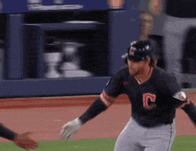 a baseball player wearing a black jersey with the letter c on it
