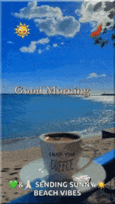 a cup of coffee is sitting on a saucer on a beach next to the ocean .