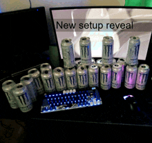 a bunch of monster cans are on a desk in front of a monitor