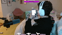 a person wearing headphones is sitting in front of a microphone and looking at a phone