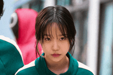 a girl in a green sweater looks at the camera
