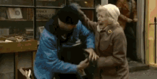 an elderly woman is being attacked by a man in front of a store that sells books