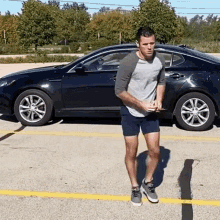 a man is standing in front of a black car