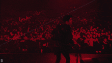 a man is dancing in front of a crowd with the letter d on the bottom