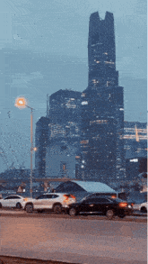 cars are driving down a street in front of a tall building