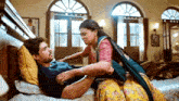 a man and woman are laying on a bed and the woman is holding the man 's arm