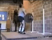 a man is lifting a barbell in a gym with a brick wall in the background