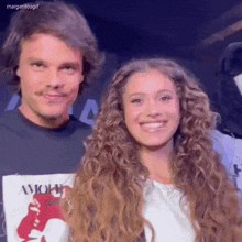 a man and a woman are posing for a picture and the woman is wearing a shirt that says " amore "