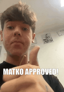 a young man giving a thumbs up with the words " matko approved " above him