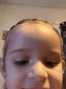 a close up of a little girl 's face with a purple background