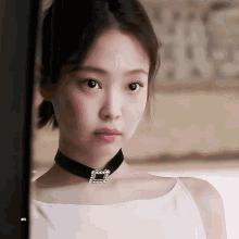 a close up of a woman wearing a choker and a white shirt
