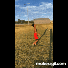 a boy in red shorts is standing in a field with his shadow on the ground