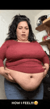 a woman with a very large belly is wearing a red shirt