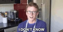 a man wearing glasses says i don 't know in a kitchen