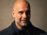 a bald man with a beard is wearing a blue sweater with the hashtag millythegoat