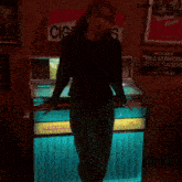 a woman is standing in front of a jukebox that says texas & southwestern cattle raisers on it