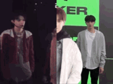 two young men are standing next to each other in front of a green wall .
