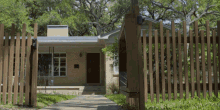 a brick house with a wooden fence in front