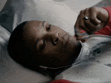 a man laying on a bed listening to music