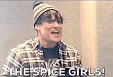 a man wearing a plaid shirt and a beanie is saying the spice girls !