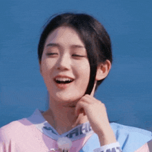 a woman wearing a pink and blue shirt with the word la on it