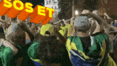 a crowd of people holding their heads in the air with a sos et sign behind them