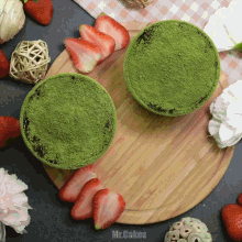 two bowls of green powder are on a wooden cutting board
