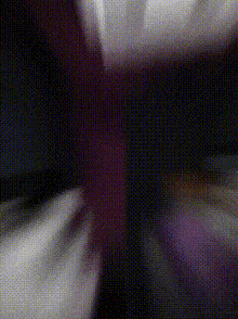 a close up of a person 's hand holding a purple object in a dark room .