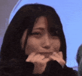 a woman is making a funny face with her hands on her face .