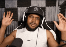 a man wearing headphones and a hat with the letter tb on it