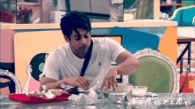 a man sits at a table with a tray of food and the name ninarika written on the table