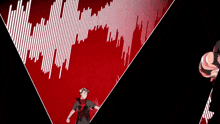 a man is standing in front of a red and white wave