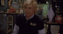 a young man wearing a black shirt with the letters kat on it