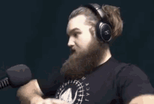 a man with a beard is wearing headphones and a ponytail .