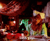 a woman sitting at a table with the words liv & yayi written on the bottom